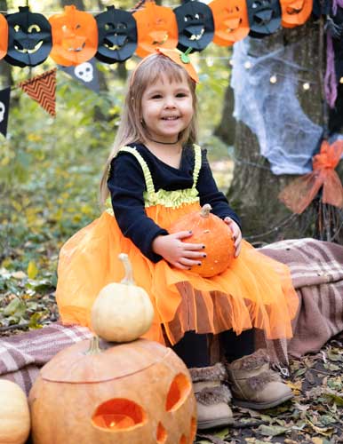 Cute girl sitting at a campsite, holding a pumkin